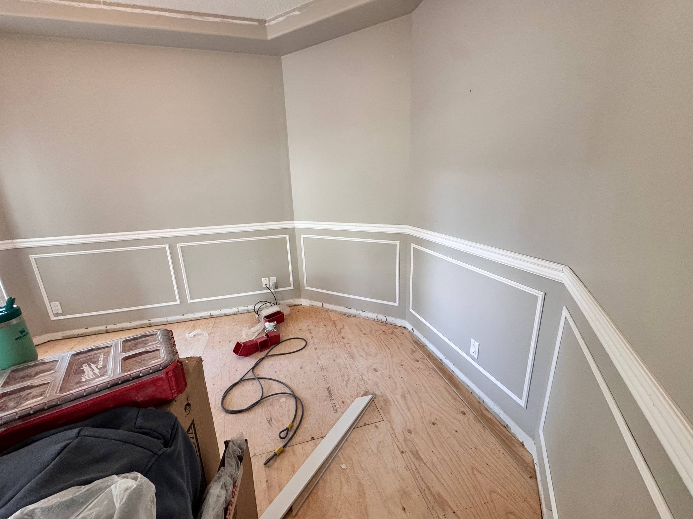 Room with new picture-frame wainscoting and chair rail along every wall, before flooring went in