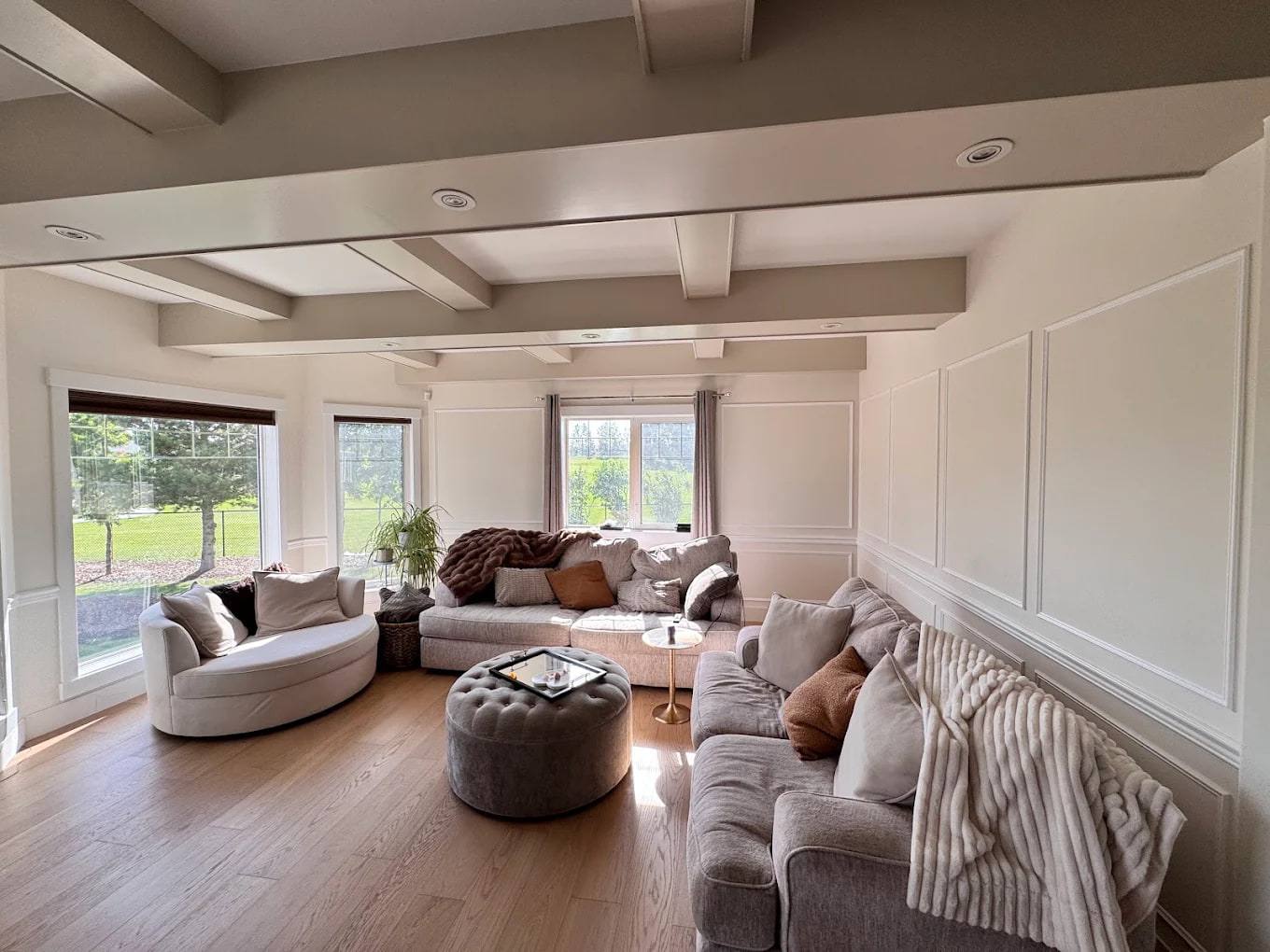 Living room with white chair rail wainscoting, tall picture-frame panels and a beamed coffered ceiling