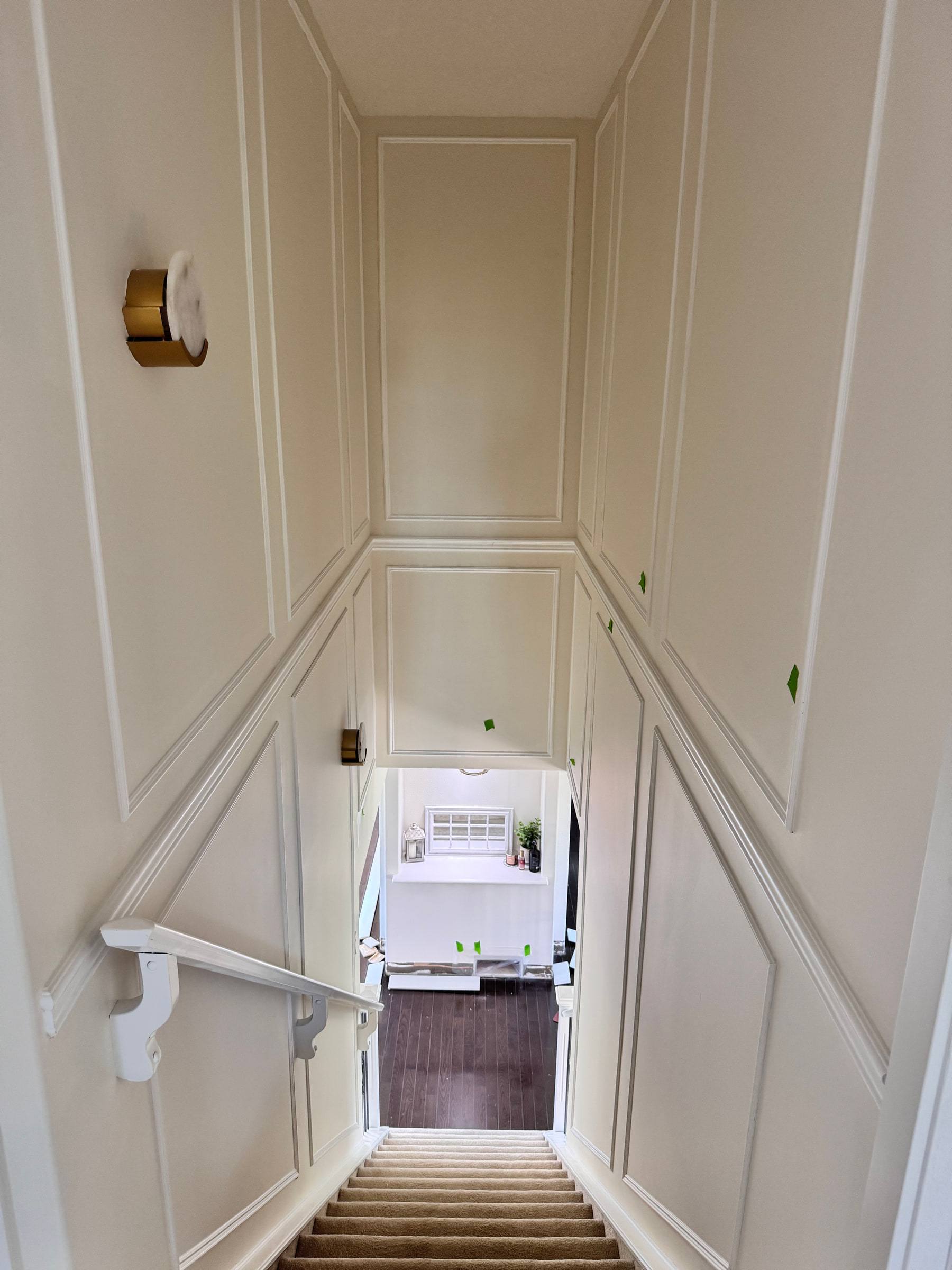 Stairwell with picture-frame panel moulding running up both walls toward the upper floor