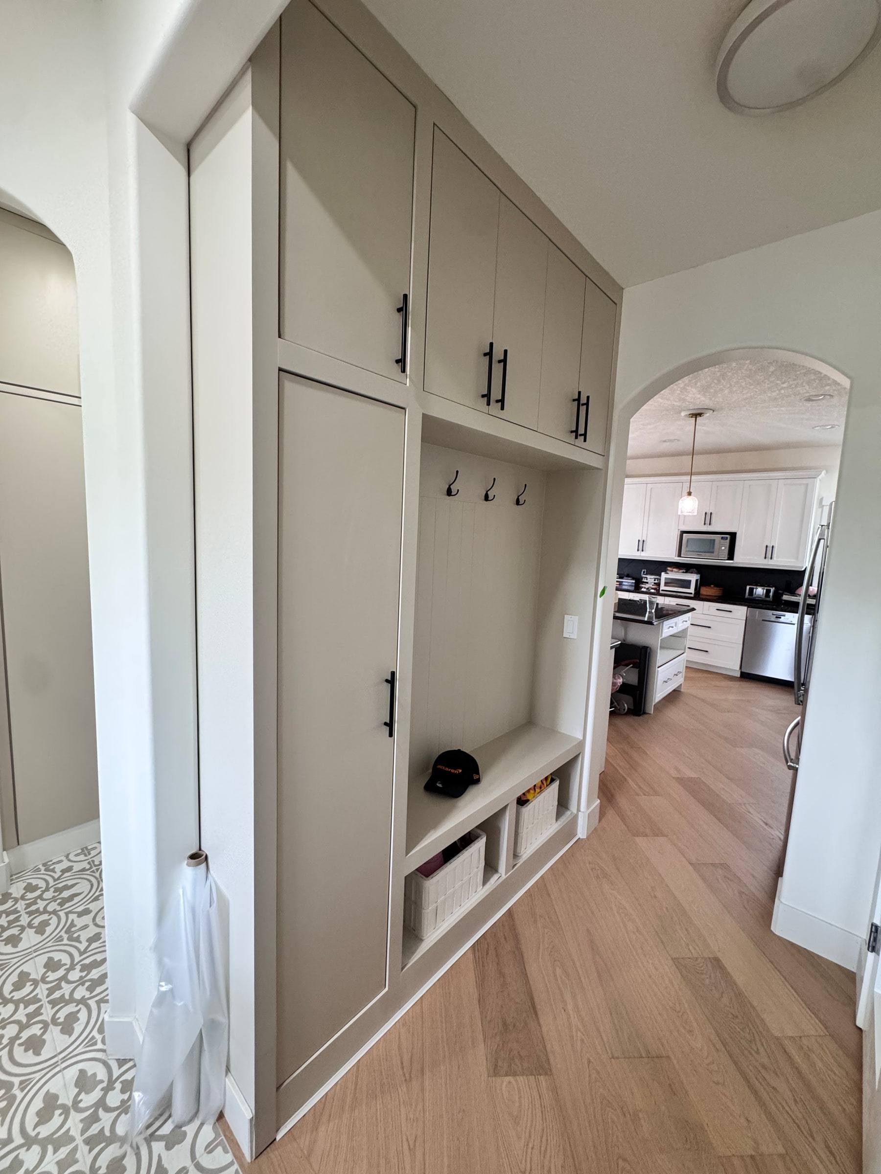 Mudroom lockers seen from the hallway through an arched opening into the kitchen