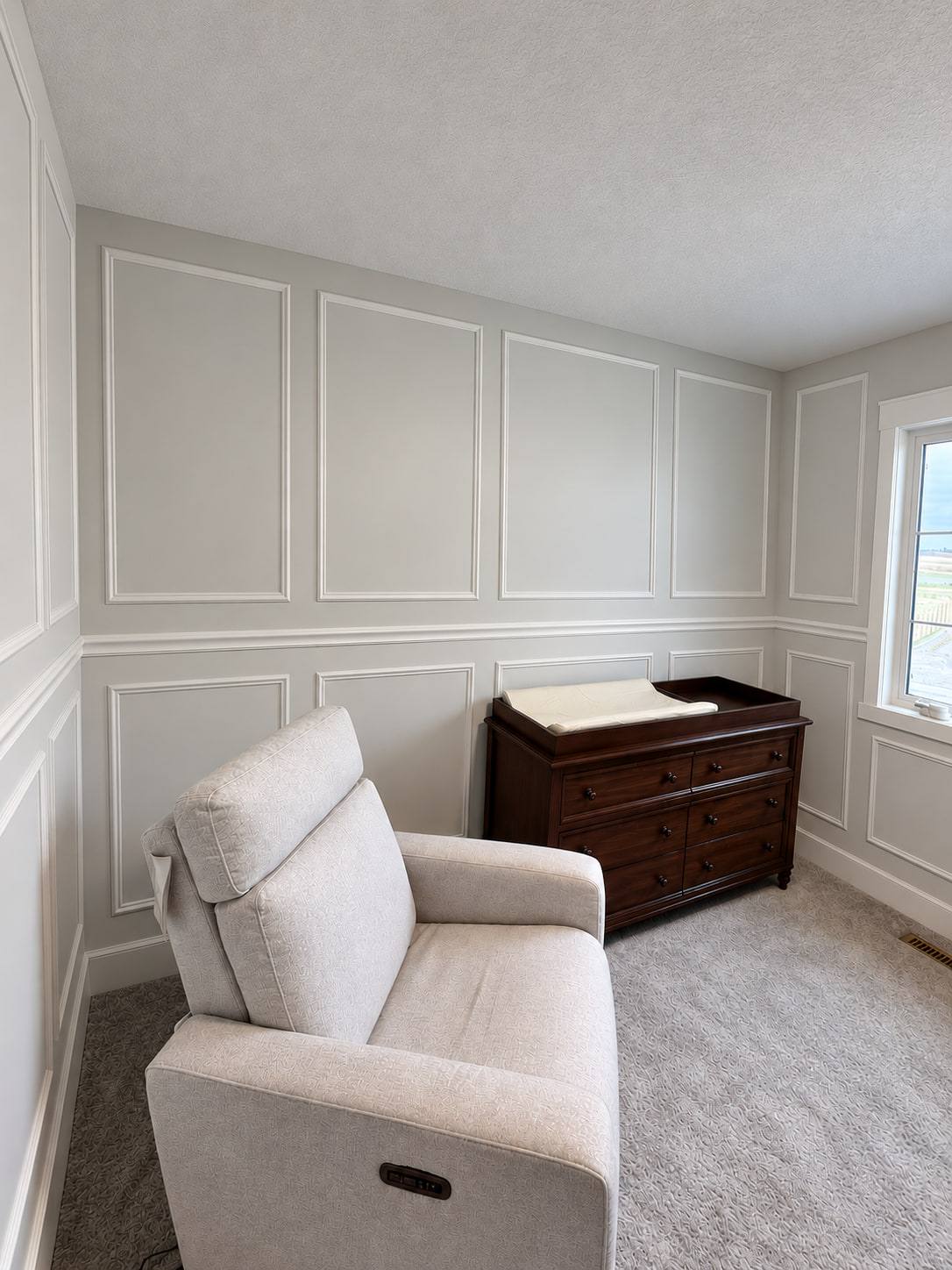Bonus room with picture-frame panels above a chair rail and wainscoting below
