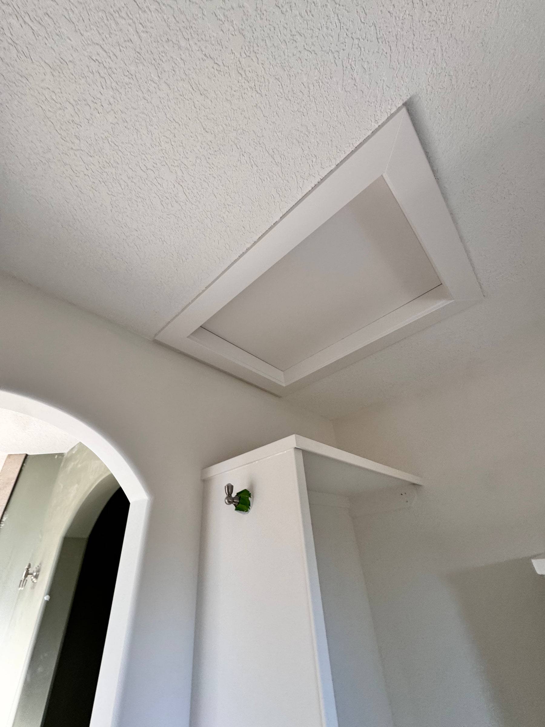 Attic hatch in the ceiling framed with new trim